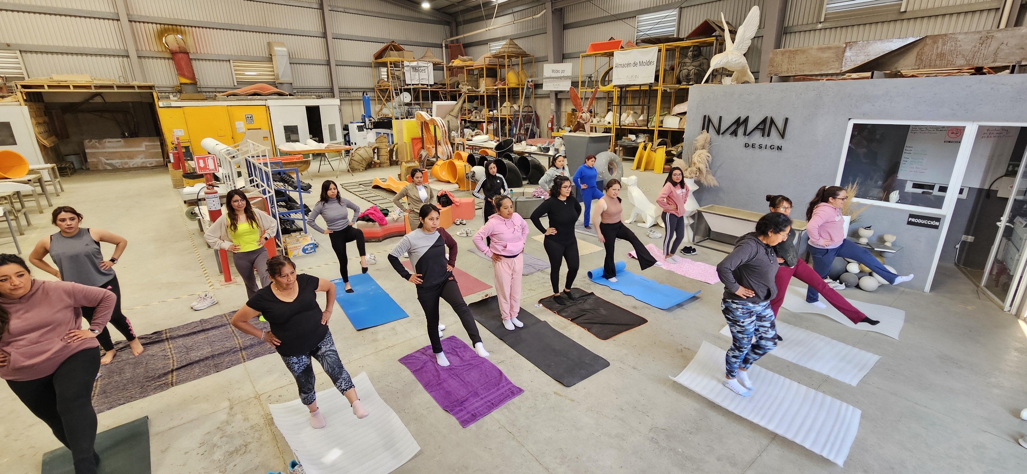 Colaboradoras practicando yoga en la planta de Inman Design.